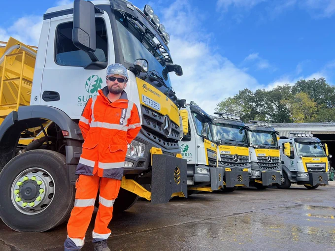 Gritters lined up with a highways manager in hi-vis