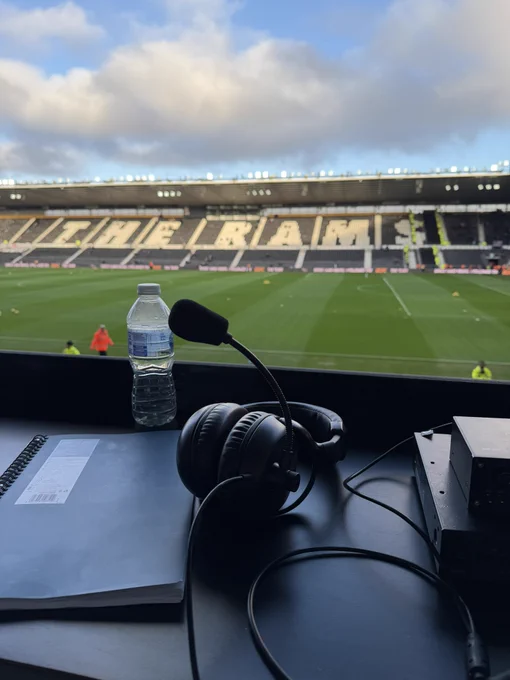 A portrait picture taken from the media area in the west stand looking across the pitch towards the east stand. Where the sun gleams onto the seats spelling out ‘The Rams’