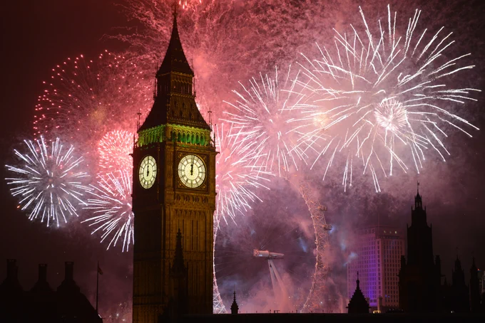 Big Ben with fireworks going off behind it.