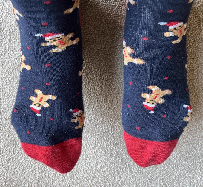 Navy Christmas socks with gingerbread men wearing Santa hats.