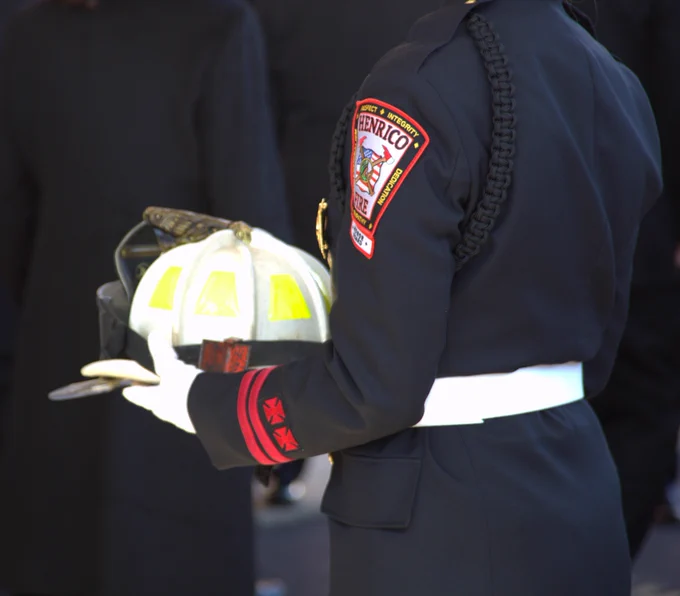 Firefighter carries Retired Assistant Chief Herman "Rocky" Hudson Fire Chief's hat during funeral service.