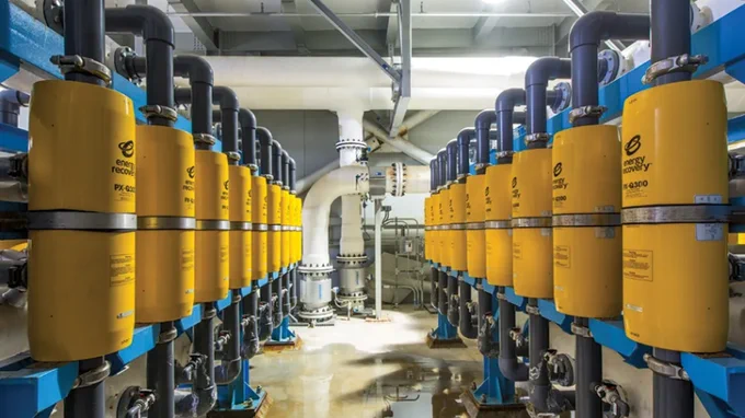 Interior view of a high-voltage electrical substation featuring an array of cylindrical Schneider Electric capacitor banks and insulated piping. Image Credit:
Energy Recovery