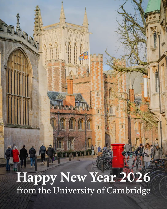 A scenic view of the Trinity Street in Cambridge, with historical buildings, pedestrians, and a bright red post box. A text overlay at the bottom of the image reads: "Happy New Year 2026 from the University of Cambridge".