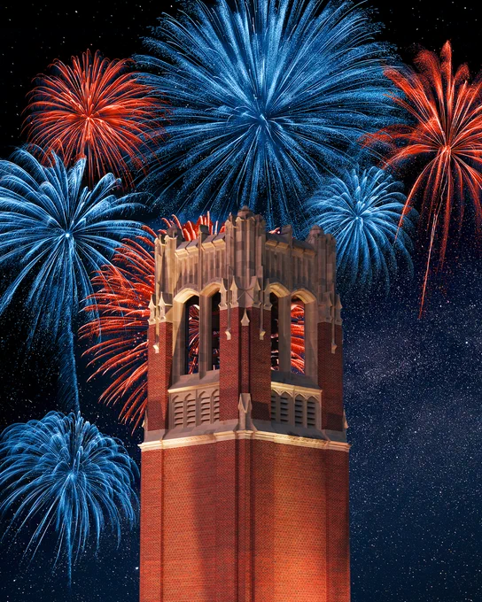 Fireworks burst in blue and orange above century tower. 