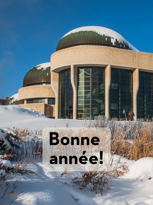 Vue extérieure du Musée canadien de l'histoire avec des toits couverts de neige, se détachant sur un ciel bleu clair. Le texte 'Bonne Année !' est affiché au premier plan.