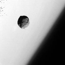 Black and white image of Janus taken by Cassini with the limb of Saturn in the background. Image ISS-NA: 1_N1537920449.122 taken 9-25-2006