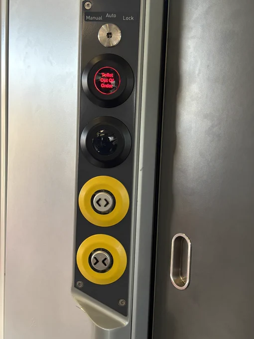 Photo of a toilet door on a train with out of order sign.