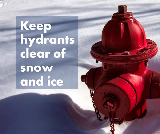 Red fire hydrant partially surrounded by snow with a message to keep hydrants clear of snow and ice.