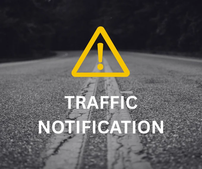 Black and white close up image of a road with the text "Traffic Notification" and a yellow rectangle with exclamation mark in it.