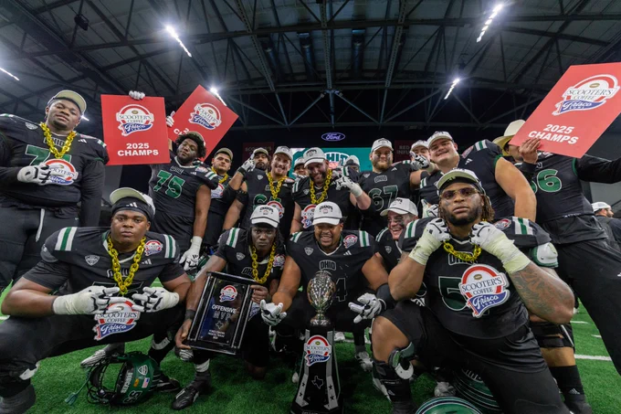 Football team celebrates with a trophy.