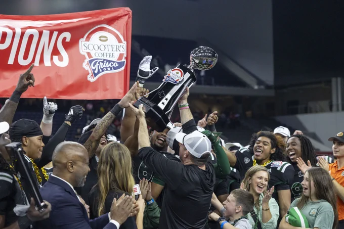 Football team celebrates with a trophy.