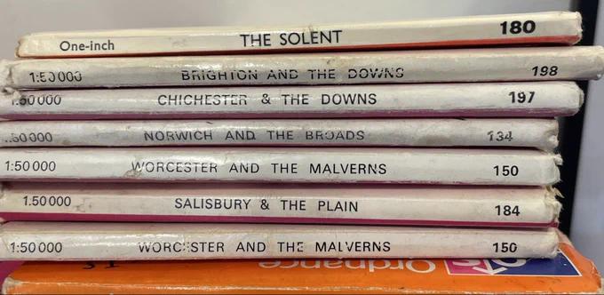 A pile of Ordnance Survey maps, looked at edge on so you can read the titles.
