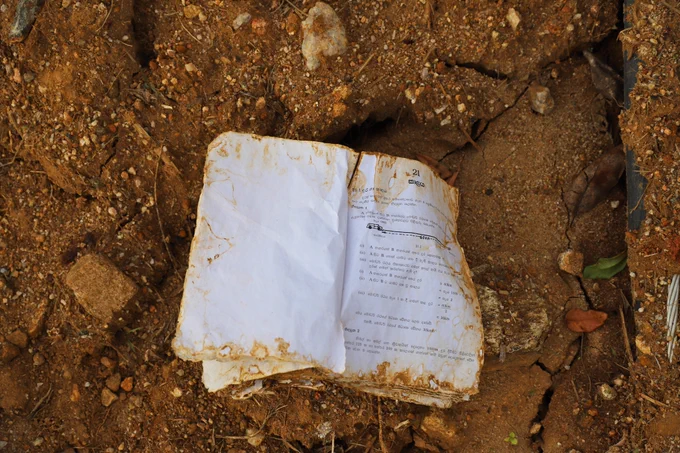 Photo 02:A Grade Nine mathematics textbook lies among the debris of destroyed homes at the lower edge of the devastating Rambodagama landslide. The first lesson, in Sinhala, reads Time, with a subtopic on Distance and Time,a poignant reminder of a schoolchild’s lost belongings and disrupted childhood in the wake of the disaster.This photograph was taken on 27 December 2025, exactly one month after the tragedy