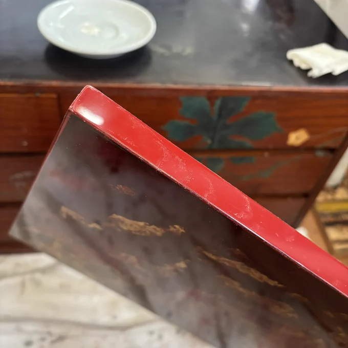 The sides are being polished, with the red urushi lacquer showing a smooth, glossy sheen.

側面まで艶上げしている様子。
赤漆が滑らかな光沢を帯びている。