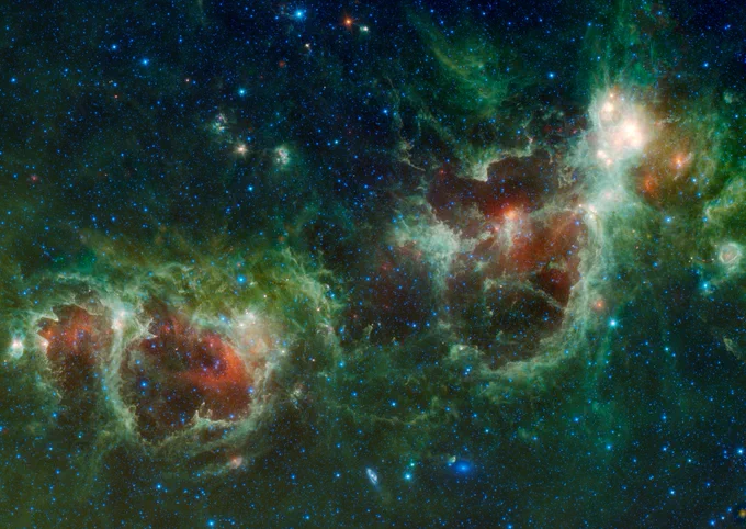 The Heart and Soul nebulae are seen in this infrared mosaic from NASA's Wide-field Infrared Survey Explorer (WISE). The nebula to the right is the Heart, designated IC 1805 and named after its shape resembling a human heart. To the left is the Soul nebula. Both nebulae appear as green bubbles of gas lined by wispy, white clouds. Inside each are splotches of fiery red gas. Vibrant blue stars litter the entirety of the scene. Credit: NASA/JPL-Caltech/UCLA