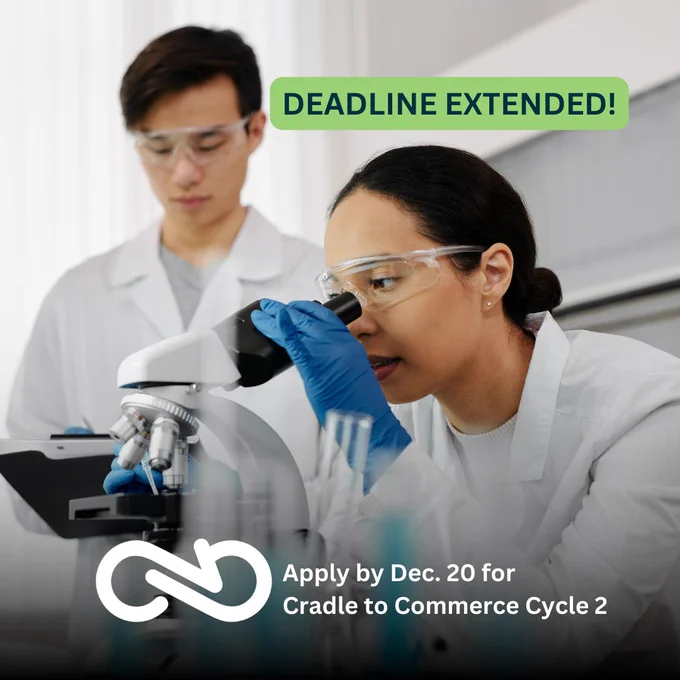 A scientist with blue gloves and a white lab coat looks into a microscope, while another scientist with blue gloves and a white lab coat takes notes to the side. The graphic's text reads: DEADLINE EXTENDED! Apply by December 20th for Cradle to Commerce Cycle Two.