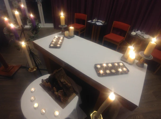 Lit candles and wooden Nativity