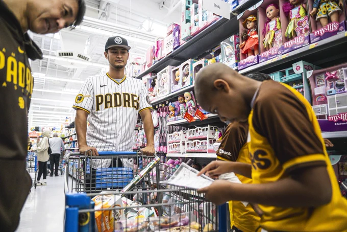 Photo of Yu Darvish and his translator Shingo Horie at today’s holiday shopping event with students from Perkins Elementary School. Yu is wearing his Padres home white pinstripe jersey and Shingo is wearing a brown Padres hoodie. Yu is pushing a cart while the students look at what to grab next from their Christmas wish list.