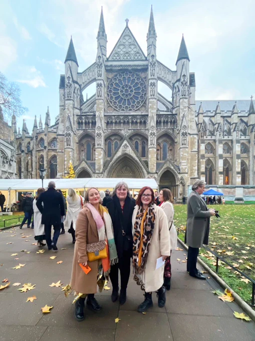 Our Chair, Sue the volunteer and one of the mums whose children have taken part in our projects stand outside Westminster Abbey smiling in smart coats and scarves.