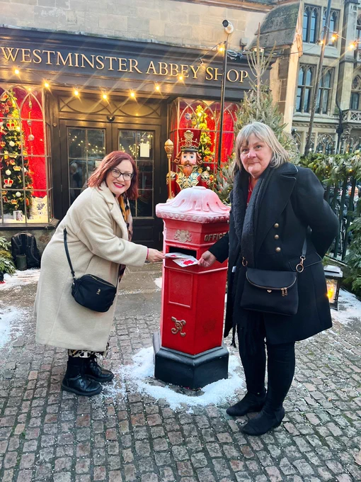 Posting Christmas cards made by children in Cadoxton into the postbox outside the Abbey.