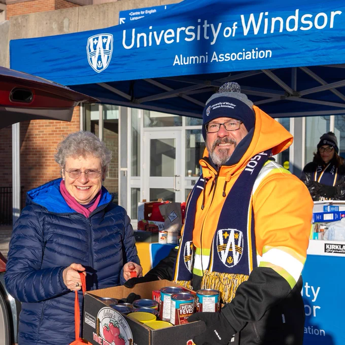 UWindsor employee donates food at Alumni Association Pop-up tent.
