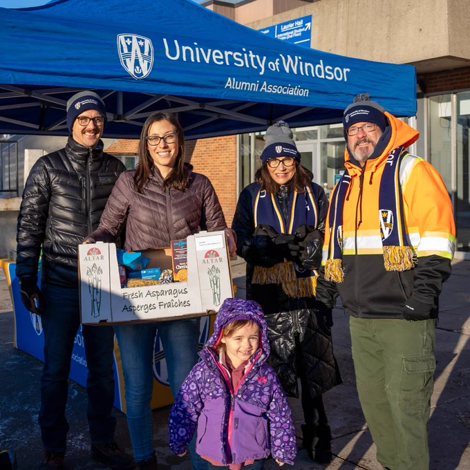 Group of UWindsor alumni and community donating food to food drive.