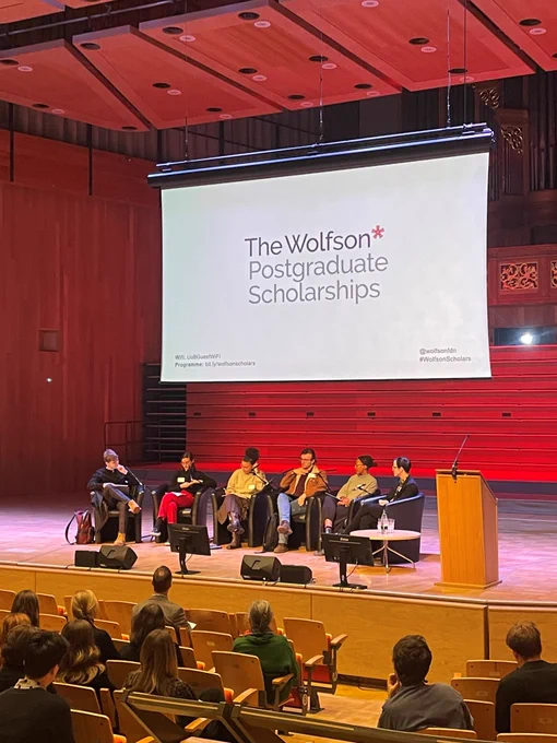 A group of students take part in a panel discussion on a stage.