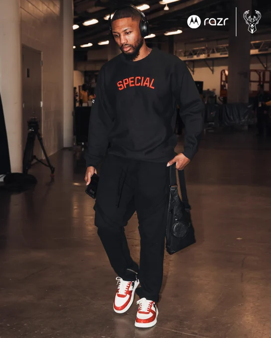 A photo of Damian Lillard walking into the Kaseya Center in Miami while wearing a black sweatshirt with "Special" in red letters in support of Special Olympics athletes.