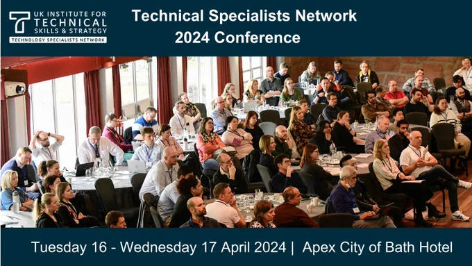 Room of technicians at conference. Graphic shows date and location of a conference