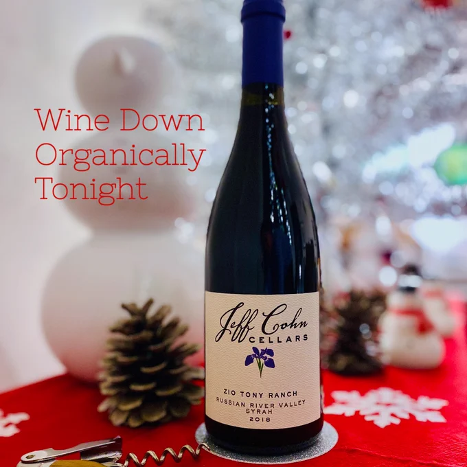 A bottle of Jeff Cohn Cellars 2018 Zio Tony Ranch Syrah on a holiday table with a corkscrew, snowmen and a retro silver metal tree.