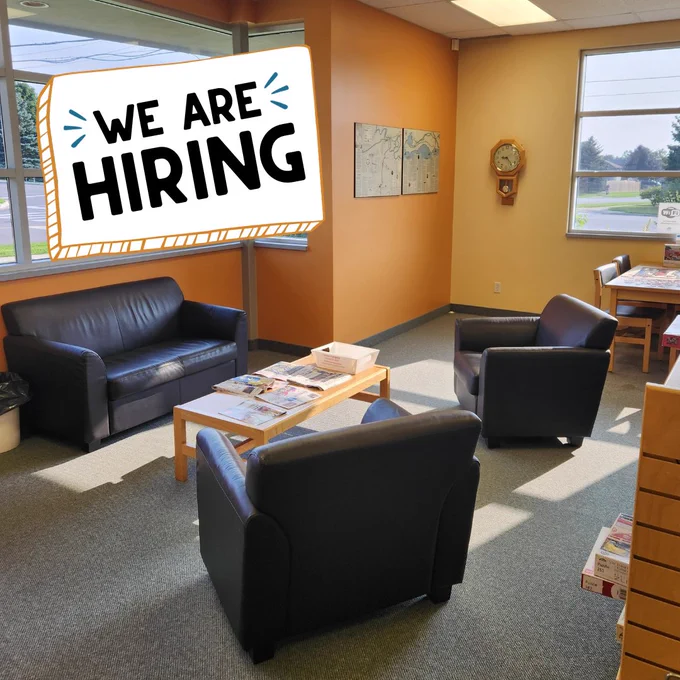 An interior picture of the St. George library branch featuring a cozy sitting and reading area. Text reads, "We are hiring."