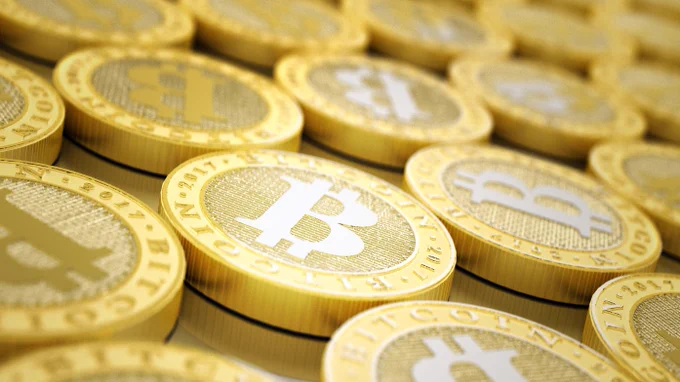 Illustration of golden coins with large "B"s displayed prominently designed to represent bitcoin.