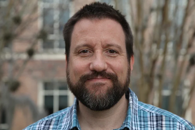 Headshot of Dr. Derek Cummings in an outdoor setting. 