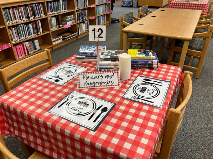 A table in the library with plastic table cover, a plastic book menu, with a section for memoirs and biographies. 