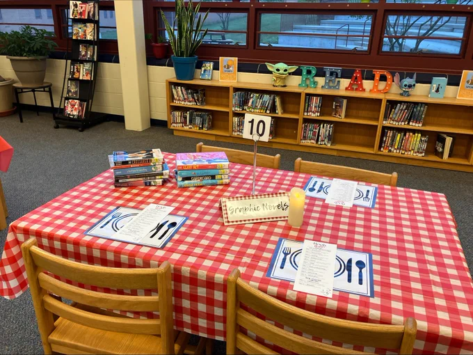 A table in the library with plastic table cover, a plastic book menu, with a section for graphic novels.