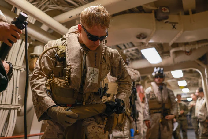 U.S. Marine Corps Cpl. Michael Fudacz, a team leader assigned to Charlie Company, Battalion Landing Team 1/5, 15th Marine Expeditionary Unit, dons a life preservation unit while preparing for a tactical recovery of aircraft personnel mission walkthrough aboard the amphibious transport dock USS Somerset (LPD 25) in the Pacific Ocean, Nov. 16, 2023. The 15th MEU is currently embarked aboard the Boxer Amphibious Ready Group conducting integrated training and routine operations in U.S. 3rd Fleet. (U.S. Marine Corps photo by Cpl. Aidan Hekker)