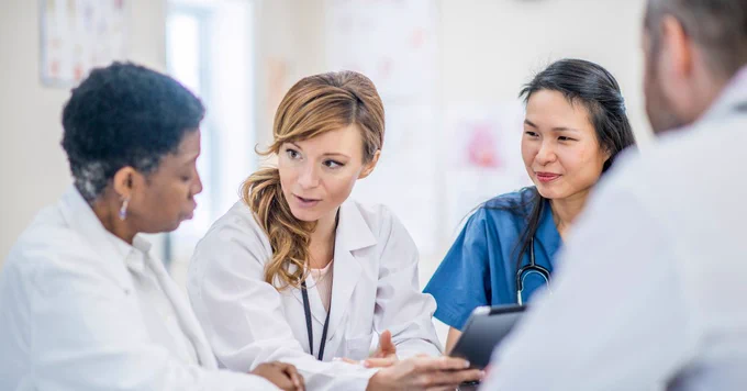 A group of doctors talking to each other about holistic disease management for diabetes.