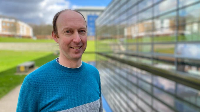 Photo of Dr Samuel Murphy standing next to Lancaster University's Postgraduate Statistics Centre