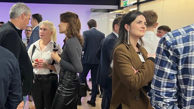 A photo of guests stood networking 