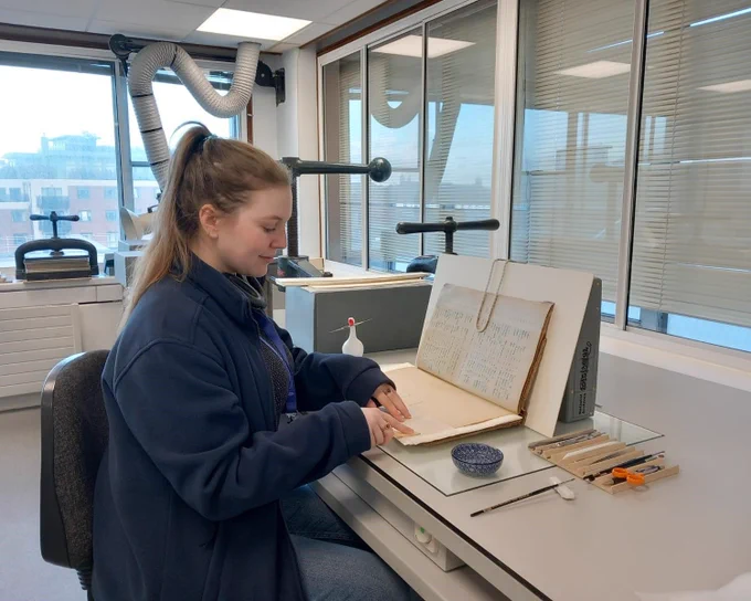 Senior Conservator Gretchen Allen carrying out in-situ repair to a volume