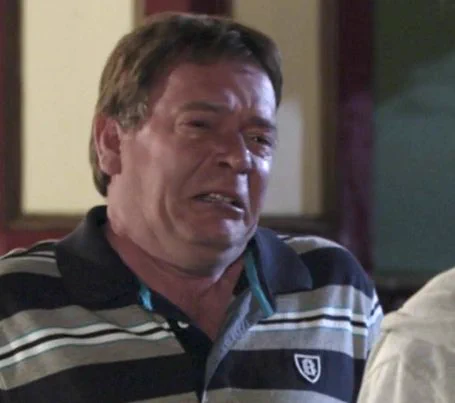Character Ian Beale from TV soap Eastenders, wearing a rugby polo shirt, his pudgy, blotchy face scrunched up mid-cry