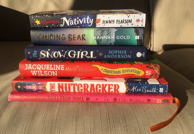 Stack of books including Animal Tales from India by Nikita Gill, The Nutcracker by Alex T Smith, The Magic Faraway Tree by Jacqueline Wilson, The Snow Girl by Sophie Anderson, Finding Bear by Hannah Gold, Operation Nativity by Jenny Pearson
