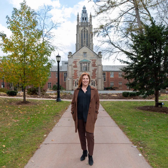 Gayemarie Brown of Perkins Access stands on the Perkins School for the Blind campus in front of the iconic Howe building tower.