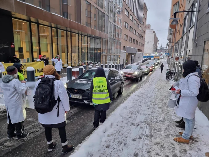 Scientists wearing lab coats are blocking the road in front of the ministry of Climate and Entreprise...headed by the Minister of Business and Industry. They hold banners, speeches, and pasted papers on the ministry. How much more climate failure can we allow?