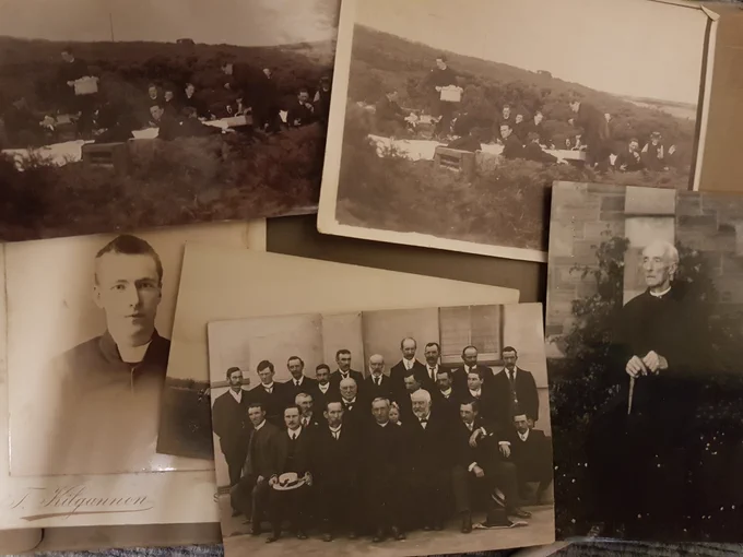A display of old black-and-white photographs showing unidentified people.