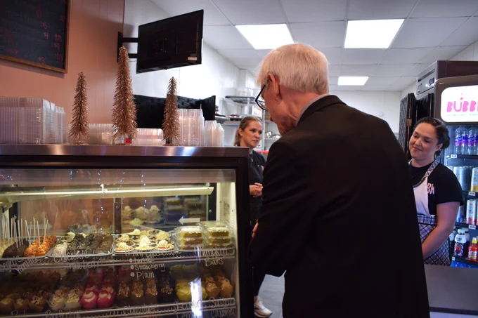 Gov. Evers checks out display case of baked treats at local bakery in Antigo.