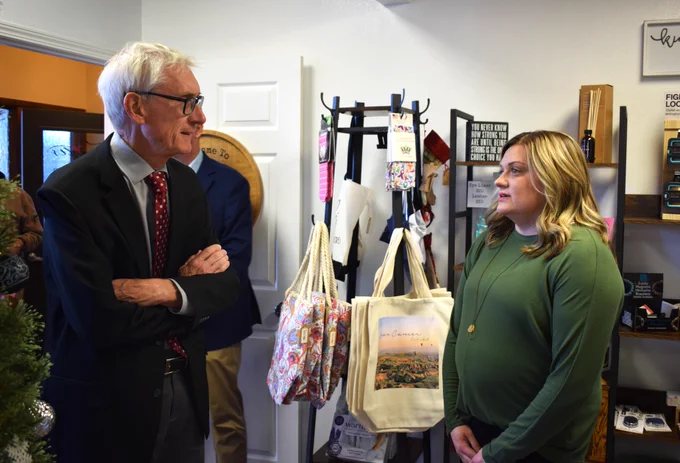 Gov. Evers talks with shop owner in her business. 