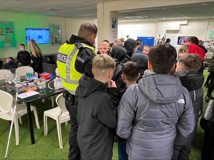Community Police Officer answering questions from young people.