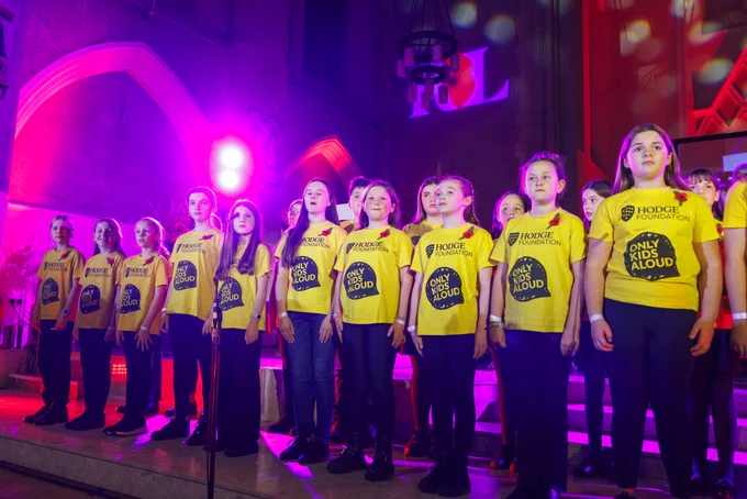 Only Kids Aloud members are standing in rows in yellow t-shirts as part of their performance at the Festival of Remembrance.