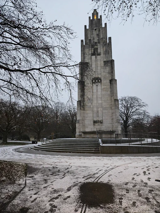 Early morning image of memorial with paths covered I light covering of snow and mist cloaking nearby trees.